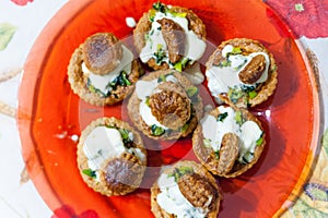 Above view of red dish full of traditional french vol au vent made of puff pastry, whipped cream and leek, on flower decorated