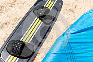 Above view surf board and kite equipment on sand beach shore watersport spot on bright sunny day against sea ocean coast