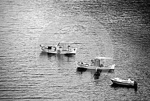 Above view of three small fishing boats in a row. Monochrome photo.