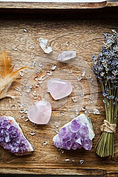 Above view of two polished pink color rose quartz crystals on wood tray in home. Attract love, healing heart chakra concept.