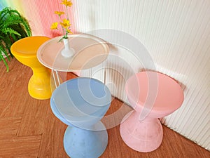 Above view of white table with three blue and pink chairs near by