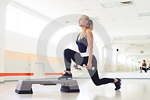 Above view of woman exercising step aerobics with dumbbells