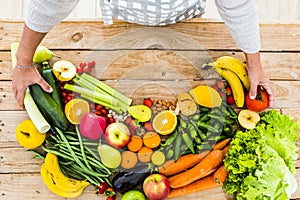 Above view of wooden table full of fresh market fruits and vegetables for healhty diet lifestyle like vegetarian or vegan for