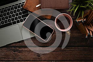 Workspace with laptop computer, coffee cup, pencil holder and mobile pone. photo