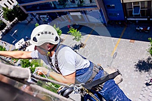 Industrial climber is washing, cleaning facade of a modern office building