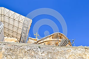 Above the wall you can see the roof of the temple and a cross against the blue sky. Jerusalem. Israel