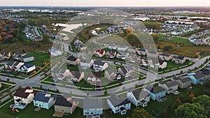 Above wide aerial view. Residential houses in suburbs near city in the evening time