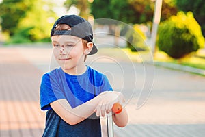 Abrasions on the face. Childhood. Cute boy learning to ride scooter