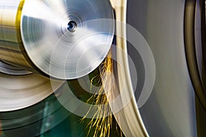 An abrasive wheel performs the grinding of a part on a circular grinding machine with sparks