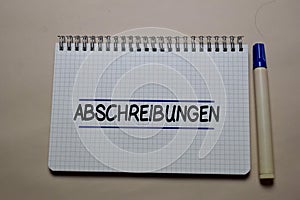 Abschreibungen write on a book isolated on office desk. German Language it means Depreciation