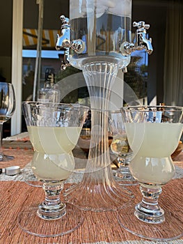 Absinth fountain with water and ice cube and four glasses and spoon