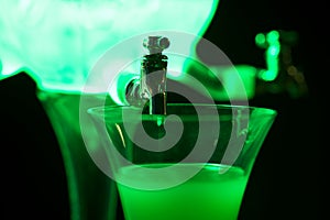 Absinth glass and fountain in green