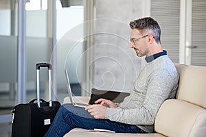 Absorbed businessman working on laptop at airport