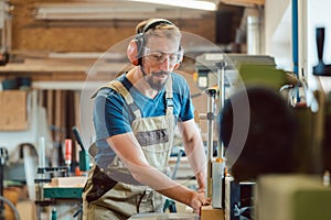 Absorbed carpenter at the milling machine working on wood