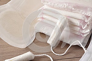 Absorbent menstrual pads and tampons on wooden table closeup