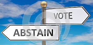 Abstain and vote as different choices in life - pictured as words Abstain, vote on road signs pointing at opposite ways to show