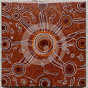 Abstract Aboriginal dot painting featuring a circular pattern with earthy tones of brown, orange, and white.