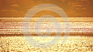 Abstract aerial sea summer ocean sunset nature background. Small waves on calm water surface in motion blur with golden