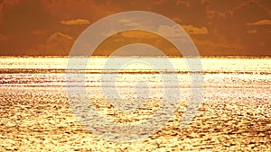 Abstract aerial sea summer ocean sunset nature background. Small waves on calm water surface in motion blur with golden