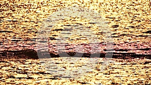 Abstract aerial sea summer ocean sunset nature background. Small waves on calm water surface in motion blur with golden