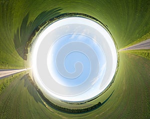 Abstract aerial view of a picturesque landscape while traveling by car on an highway in the middle of a green agricultural field