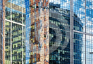 Sky and buildings are reflected in the office skyscraper facade