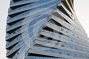 Abstract architecture, modern glass building. Close up view of a spiral modern office building at dusk