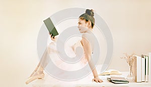 The abstract art design background of beauty lady is wearing ballet dress and satin ballet shoes,reading book,