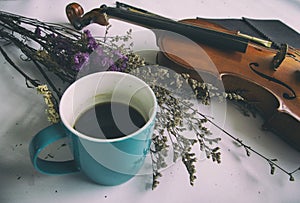 The abstract art design background of blue coffee cup put beside dried flower and violin