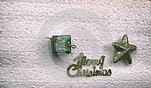 The abstract artdesign background of small gift box put beside the letter of Merry Christmas and golden star,dramatic tone