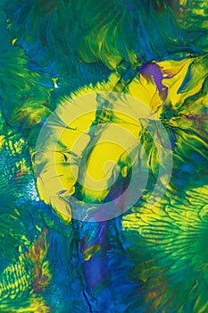 Abstract background of acrylic paint in blue, green and yellow tones.