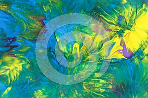 Abstract background of acrylic paint in blue, green and yellow tones.