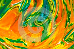 Abstract background of acrylic paint in yellow, orange and green tones