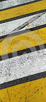 abstract background - asphalt pedestrian crossing with white and yellow stripes