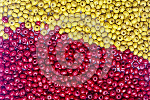 Abstract background beautiful top view red and yellow colors small wooden beads