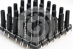 Abstract background of black plastic microswitch on white background. Electronic component spare part and industry concept.