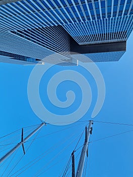 Abstract background of a blue sky with building and sailing mast