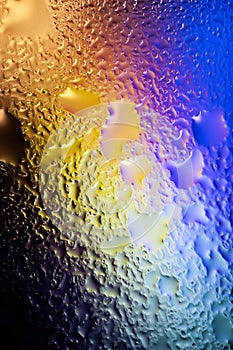 Abstract background. Abstract blur image of colored soft spots and gradients through wet glass. Texture of water drops on glass.