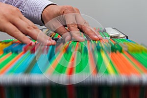 Abstract background colorful hanging file folders in drawer. Male hands looking document in a whole pile of full papers photo