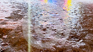 Abstract background of frozen water reflecting rainbowy neon lights. Color toning. Ice texture in winter. Soft focus