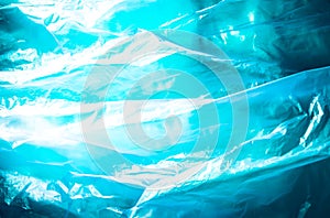 Abstract background made of blue plastic bag and back lit flash light. Grunge texture. Vibrant colors