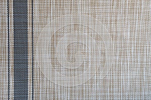 Abstract background made of brown woven matting with a gray stripe along the edge of the edge