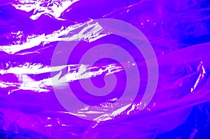 Abstract background made of ultra violet plastic bag and back lit flash light. Grunge texture. Vibrant colors