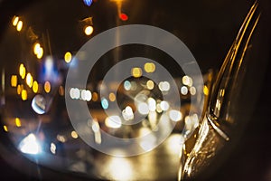 Abstract background of night city traffic jam with car lights through car mirror.