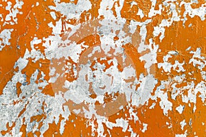 Abstract background of an old wall with cracked paint. Old weathered orange color texture. Grunge background