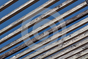 Abstract background of old wooden beams against a blue sky, outdoor architecture framing