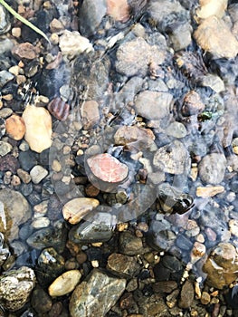 Abstract background with pebble stones in the river.