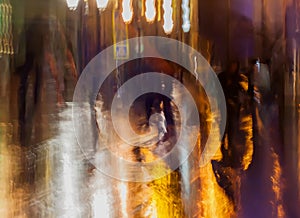 Abstract background of people figures, city street in rain, orange-brown tones. Intentional motion blur. Bright