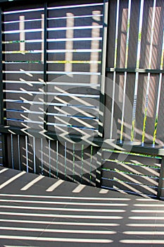 Abstract background of play of light and shadow  through ventilated wall panels in the hallway of the villa in tropics