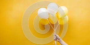 Abstract background with product discount promotion ideas. Woman hand holding a white and yellow balloon in a yellow background